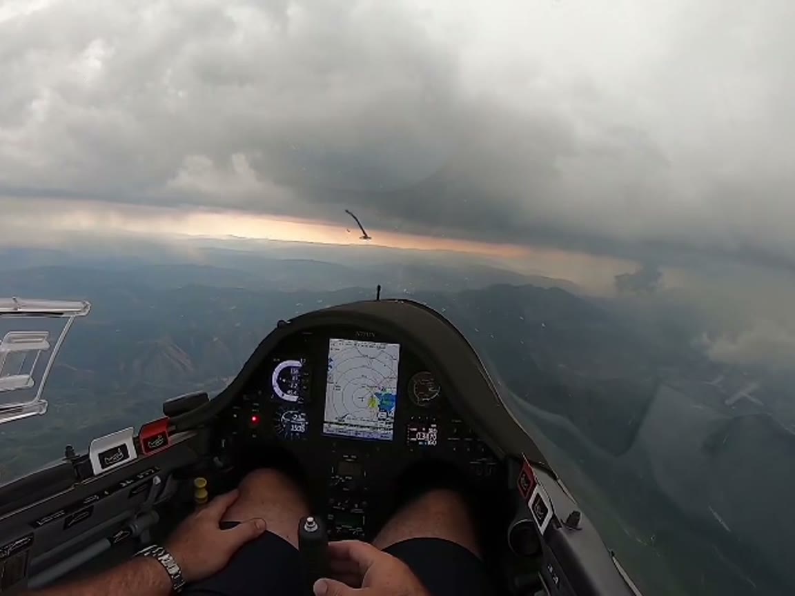 Cockpit view into storm clouds over mountains